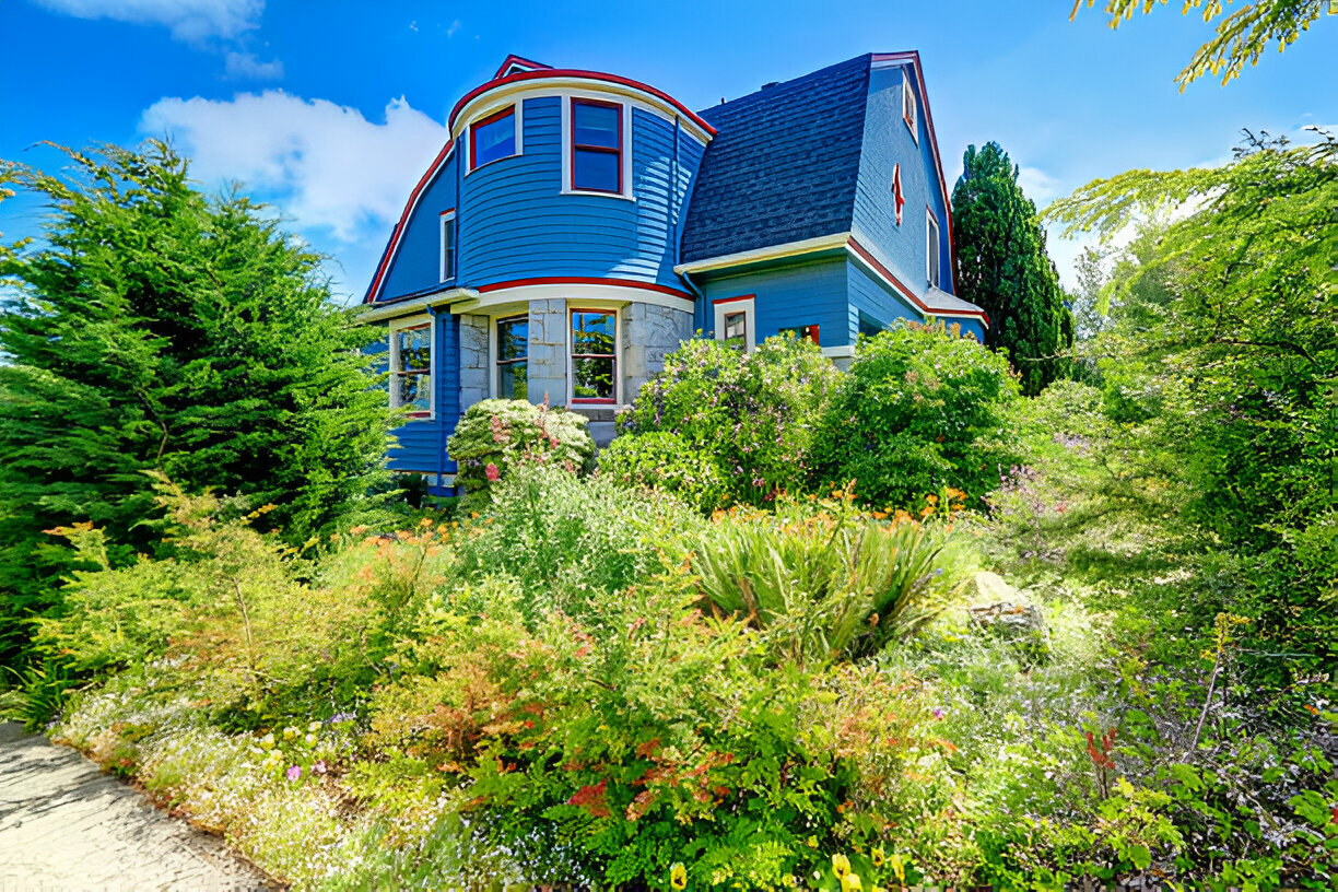 Blue Victorian-style house with lush garden and curved bay window