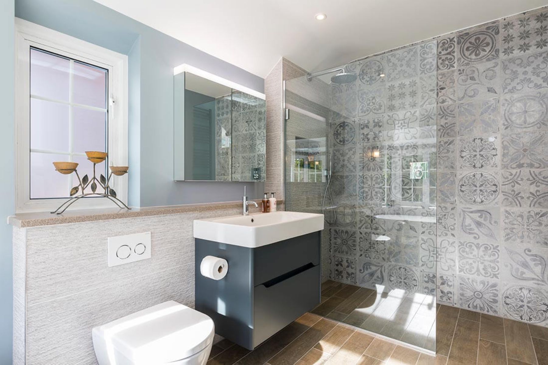 Modern wet room with patterned tiles and floating vanity 