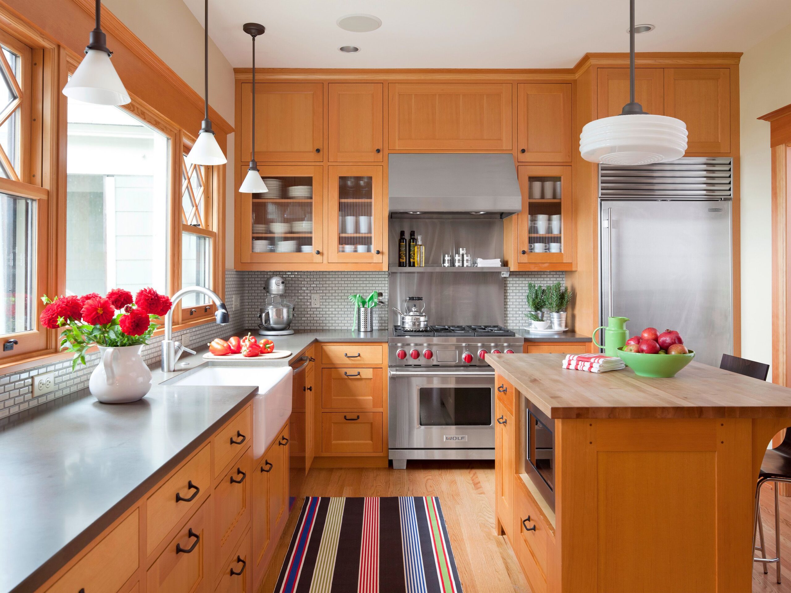 Traditional kitchen with natural wood cabinets, stainless steel appliances, farmhouse sink, and mosaic tile backsplash