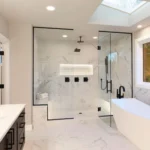 Bright modern bathroom featuring a walk-in glass shower, freestanding soaking tub, black matte fixtures, and marble-look tiles