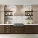 Elegant kitchen with taupe and dark wood two-tone cabinets, marble backsplash, and open floating shelves