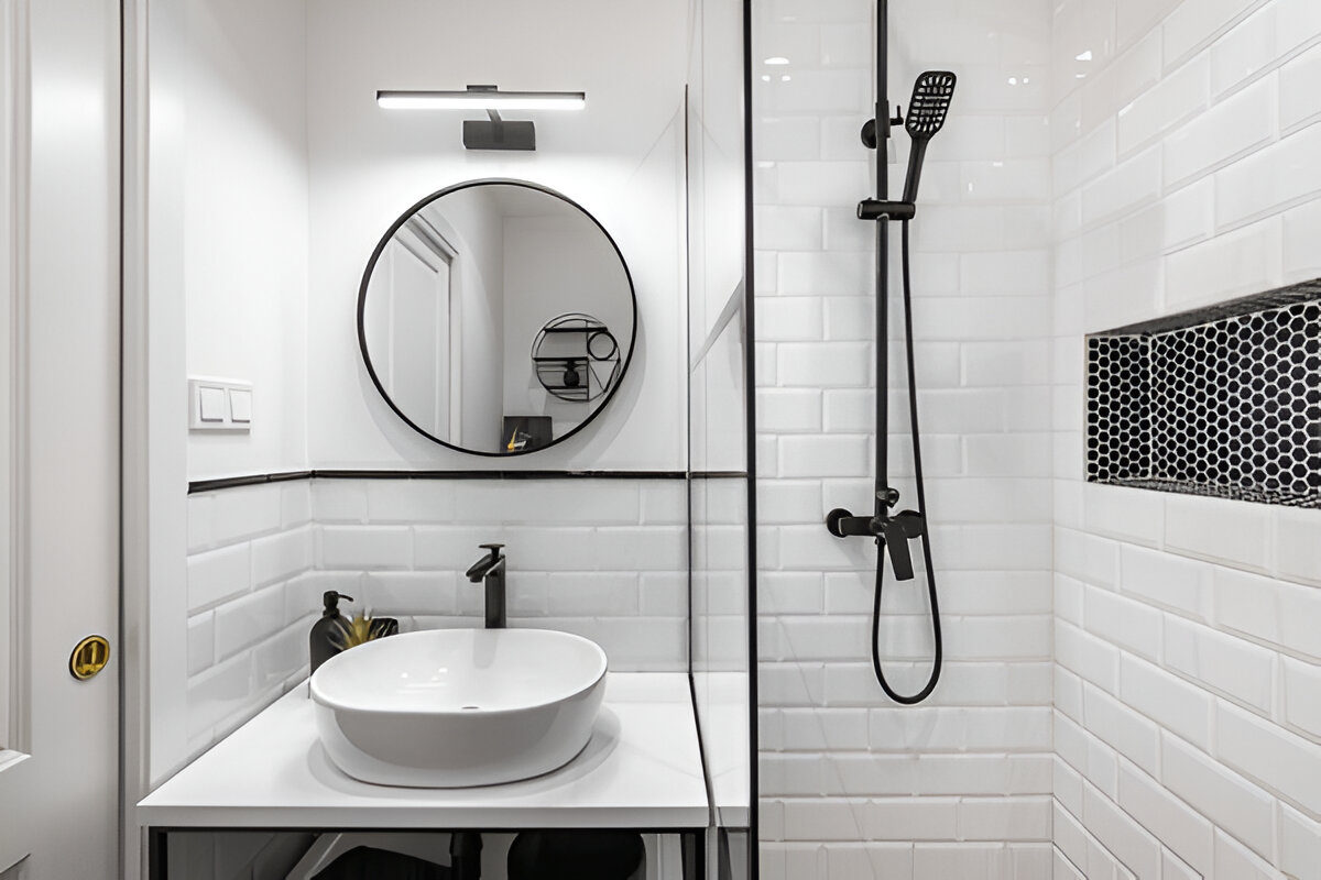 Small modern bathroom with round mirror and black fixtures