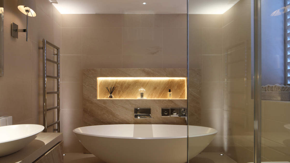 Contemporary bathroom featuring a freestanding bathtub and illuminated wall niche