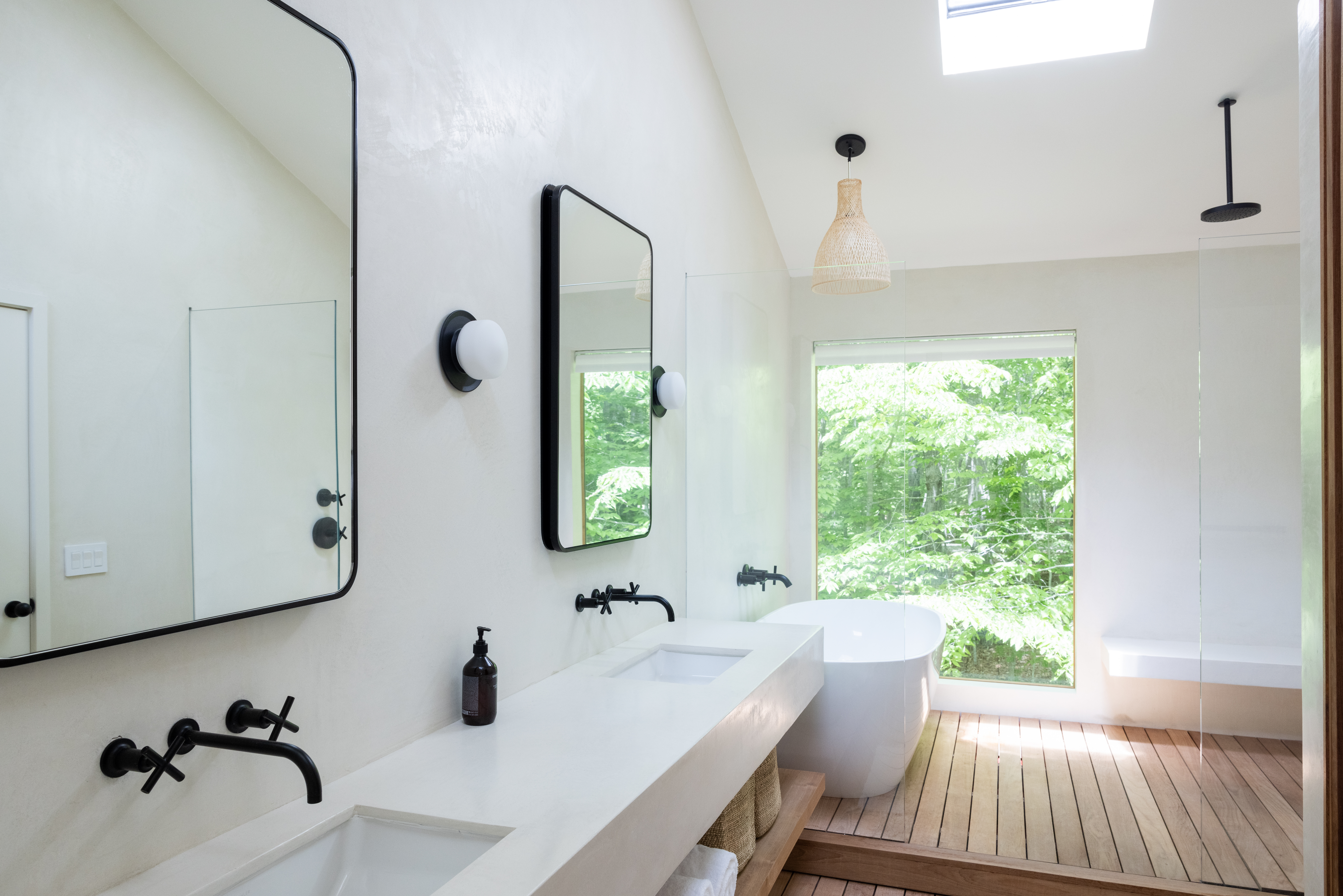  Bright minimalist bathroom with double sinks, freestanding bathtub, and large window