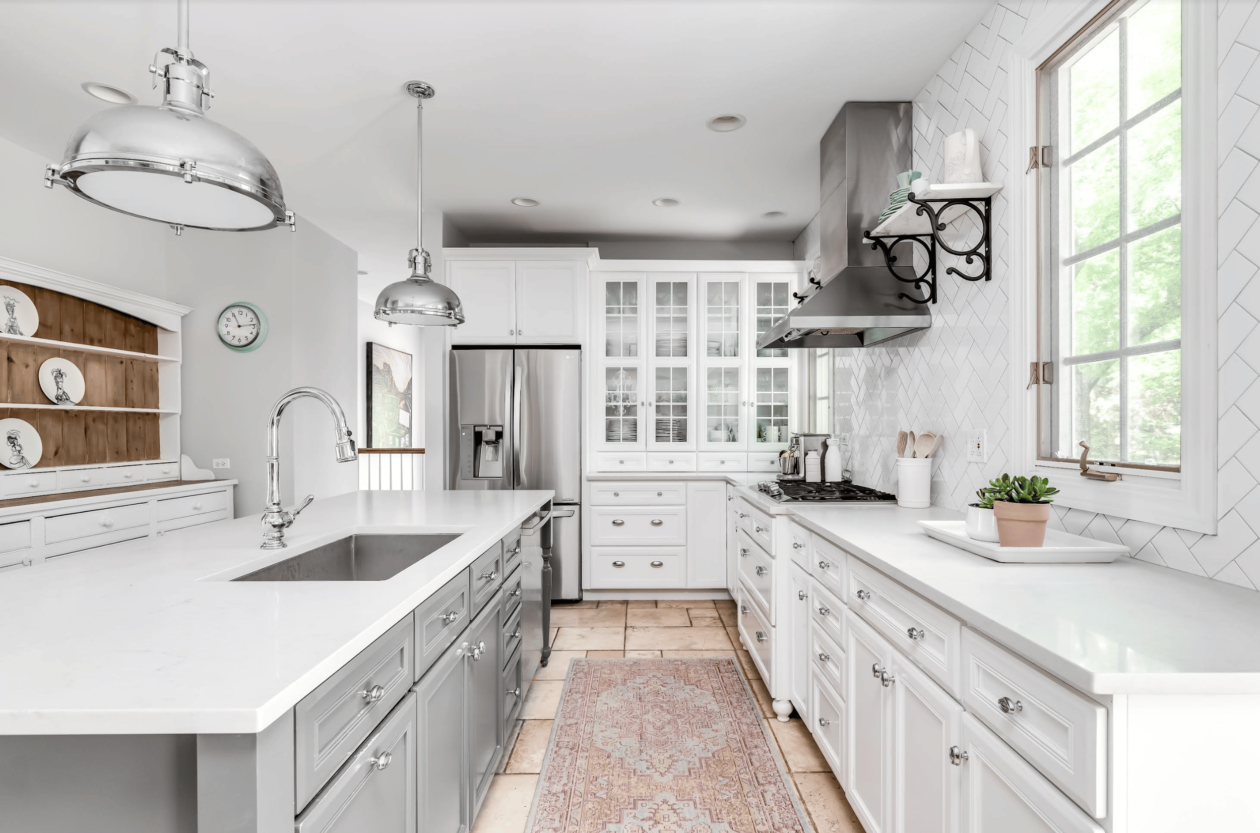 Bright white kitchen with stainless steel appliances and farmhouse-style design.