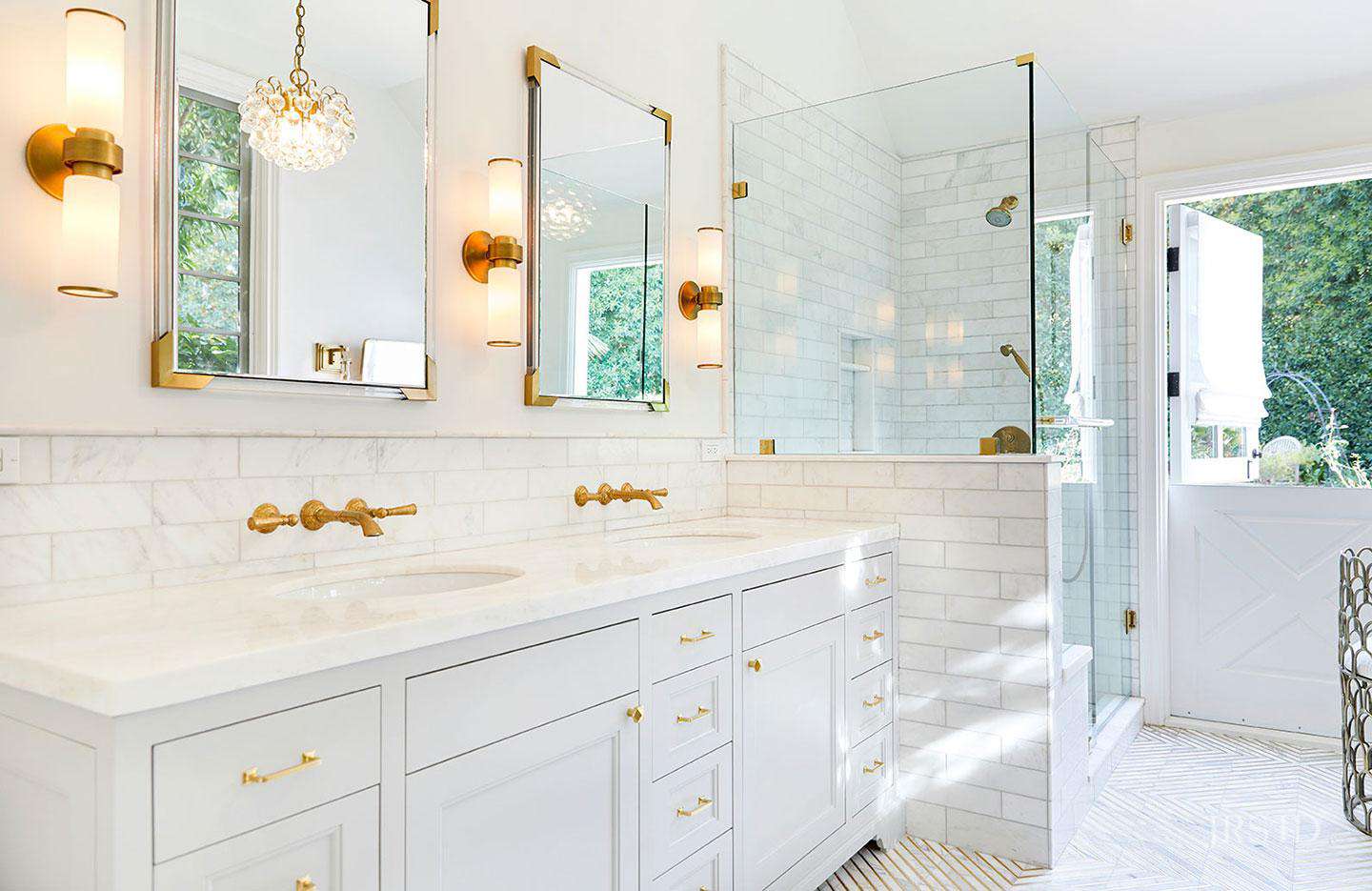 Elegant white bathroom with marble shower and gold fixtures