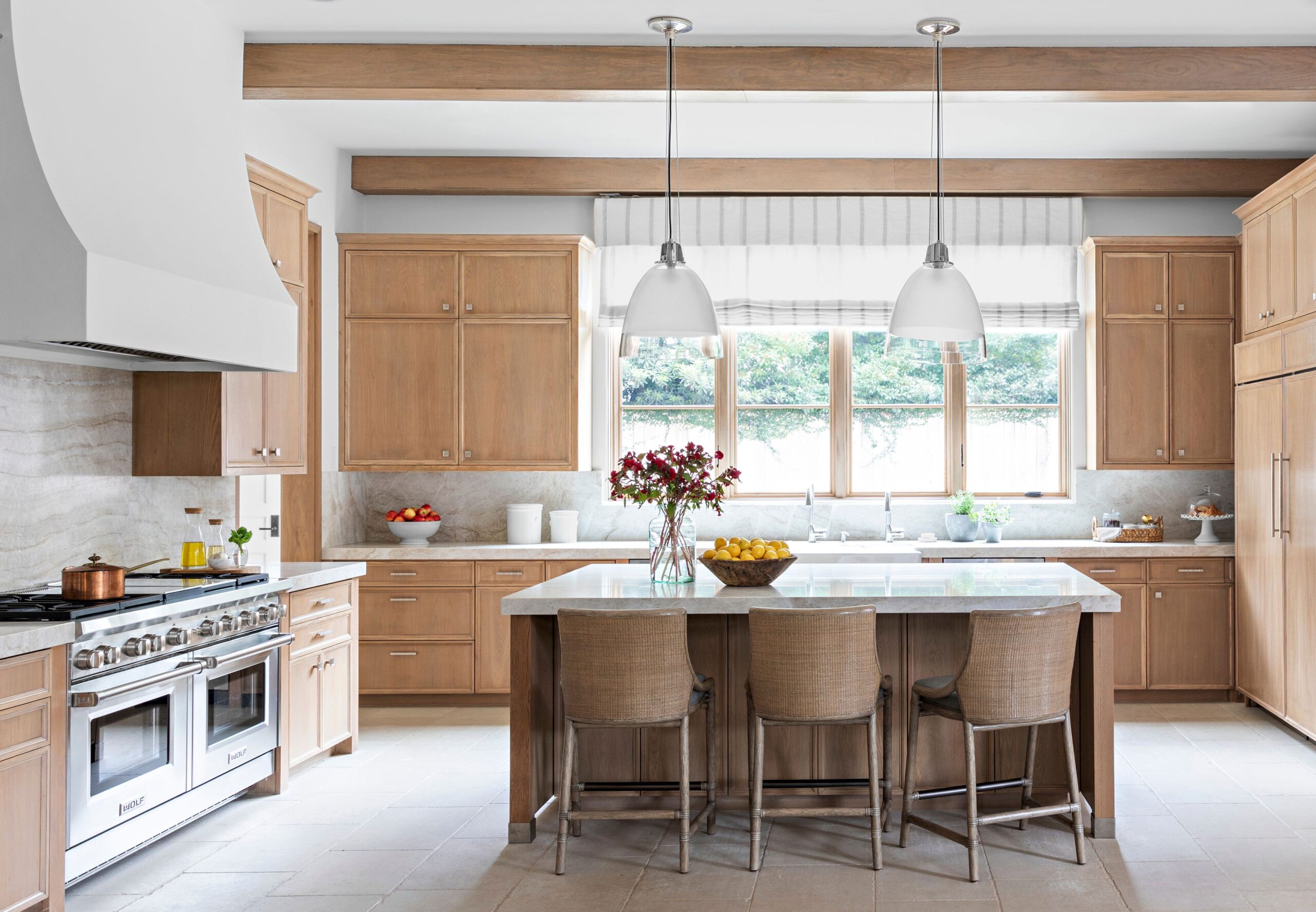 Coastal-inspired kitchen with light wood cabinets and large island.