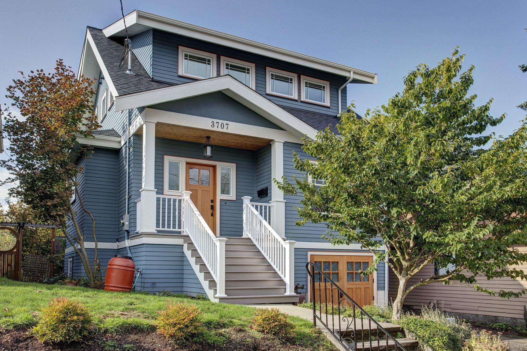 Blue two-story house with wooden front door and white trim.