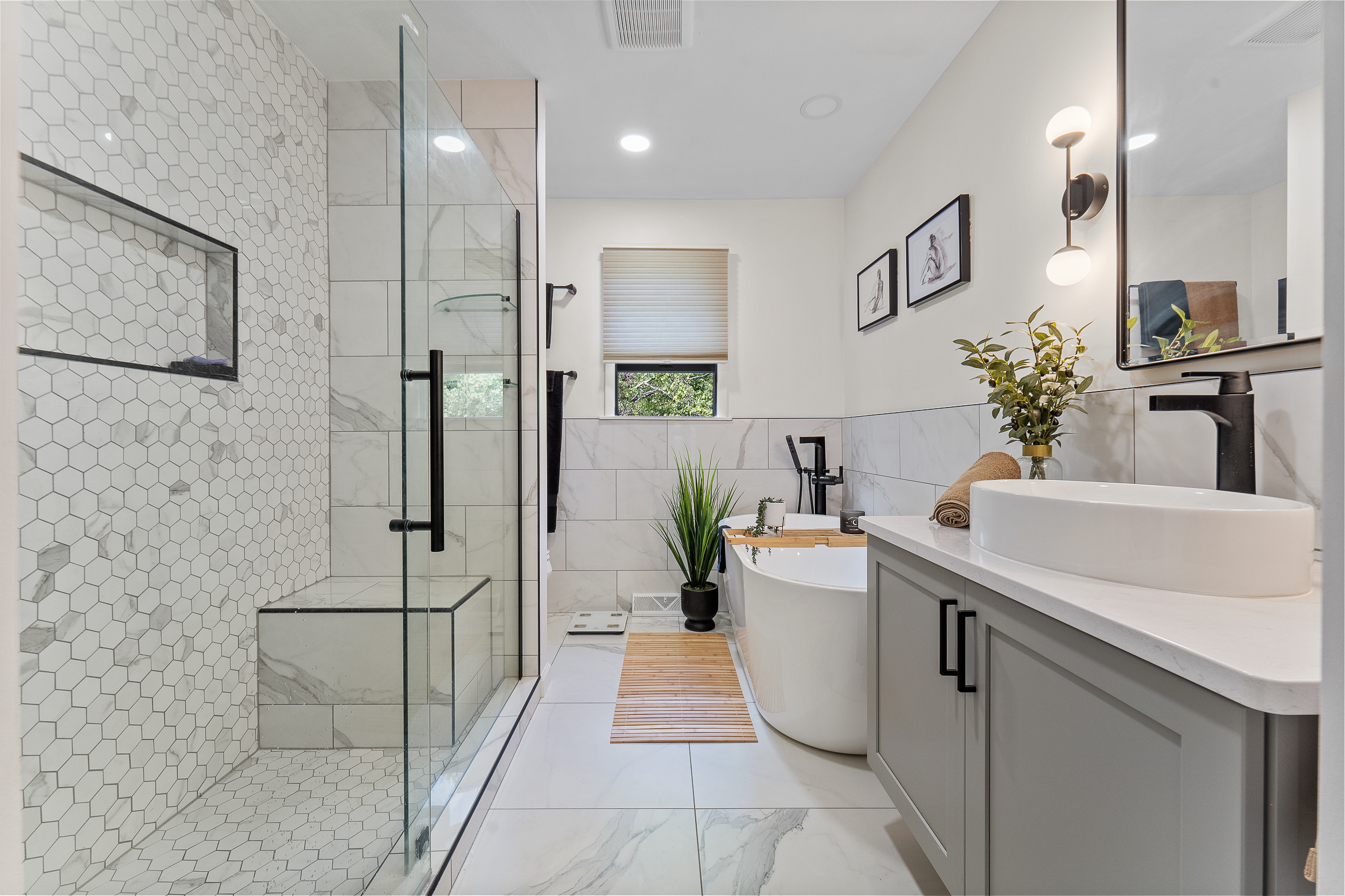 Modern bathroom with glass shower, freestanding bathtub, and elegant tile design