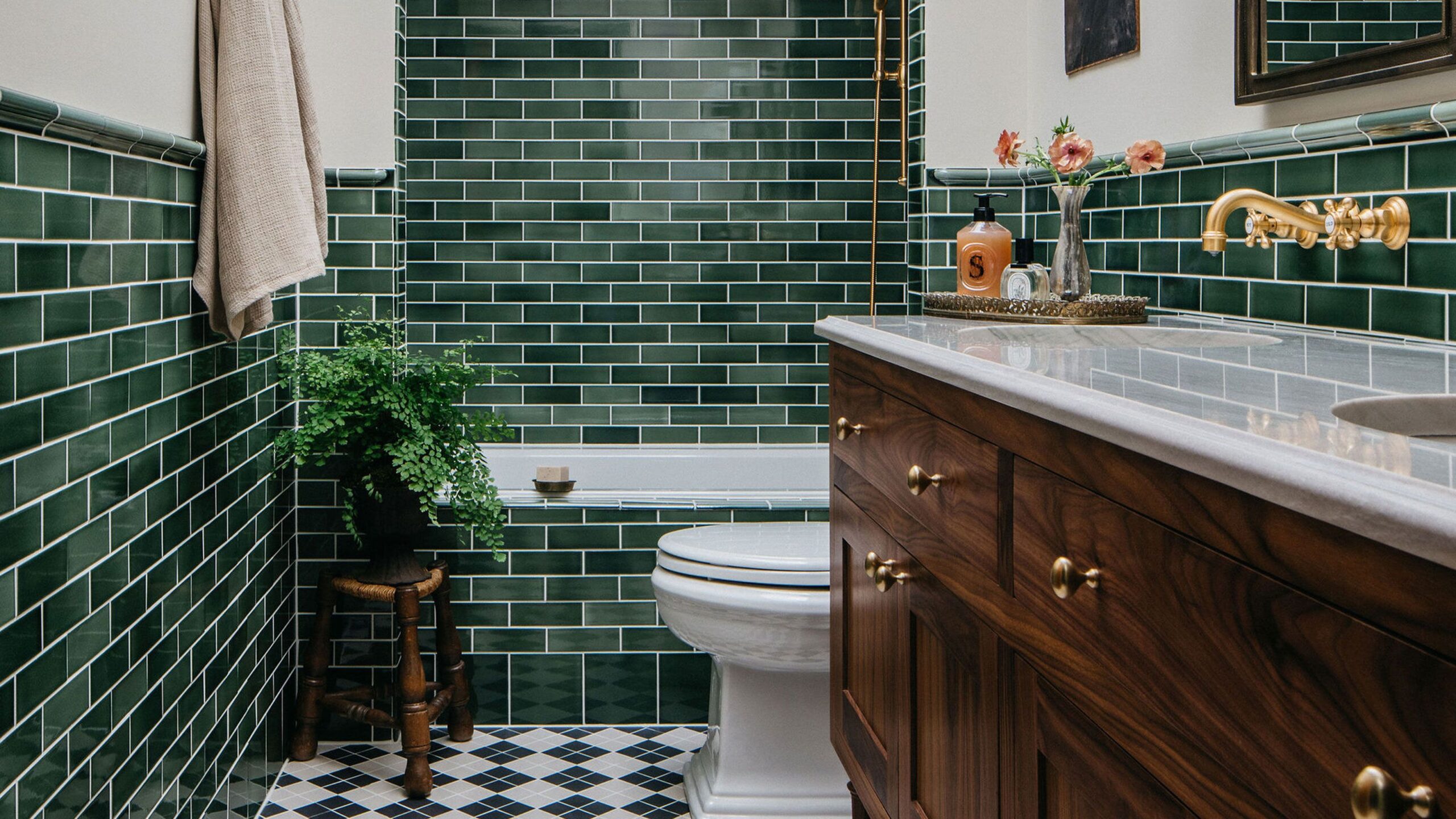 Classic bathroom with green subway tiles and wooden vanity.