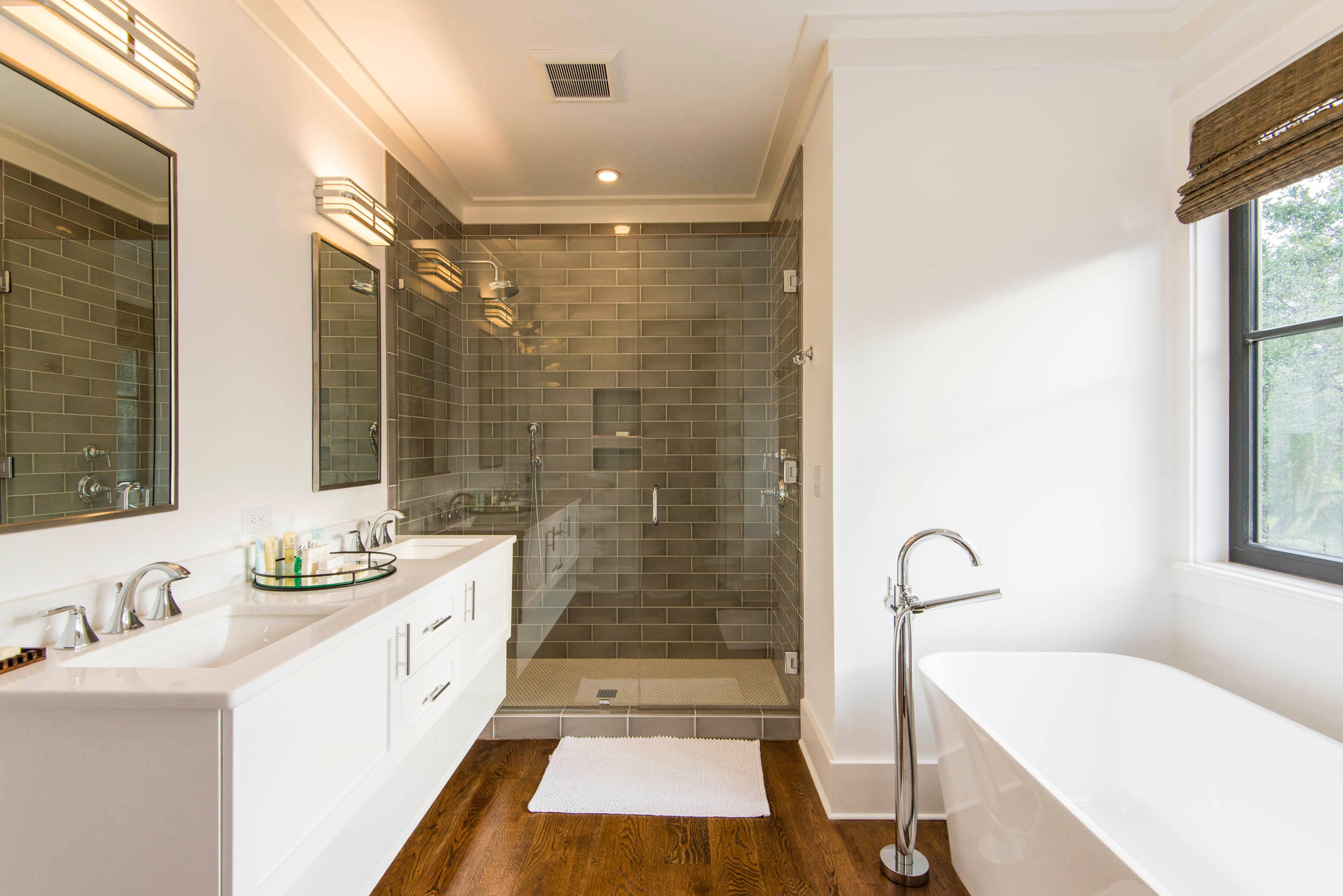 Modern bathroom with glass shower, freestanding tub, and double vanity.