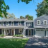 Fully remodeled two-story blue house with white trim, attached two-car garage, and front porch.