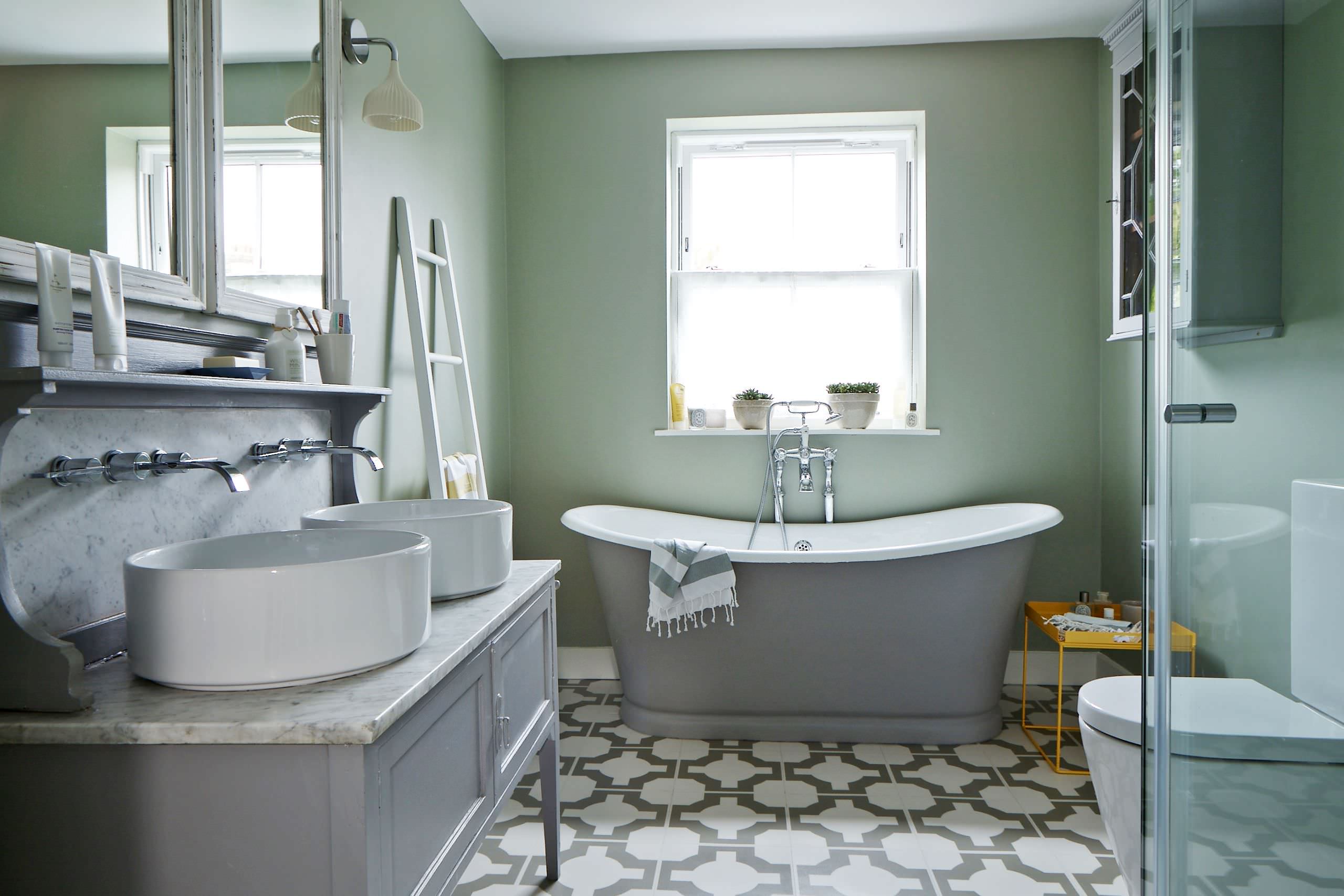 Elegant bathroom with freestanding bathtub and patterned floor tiles.