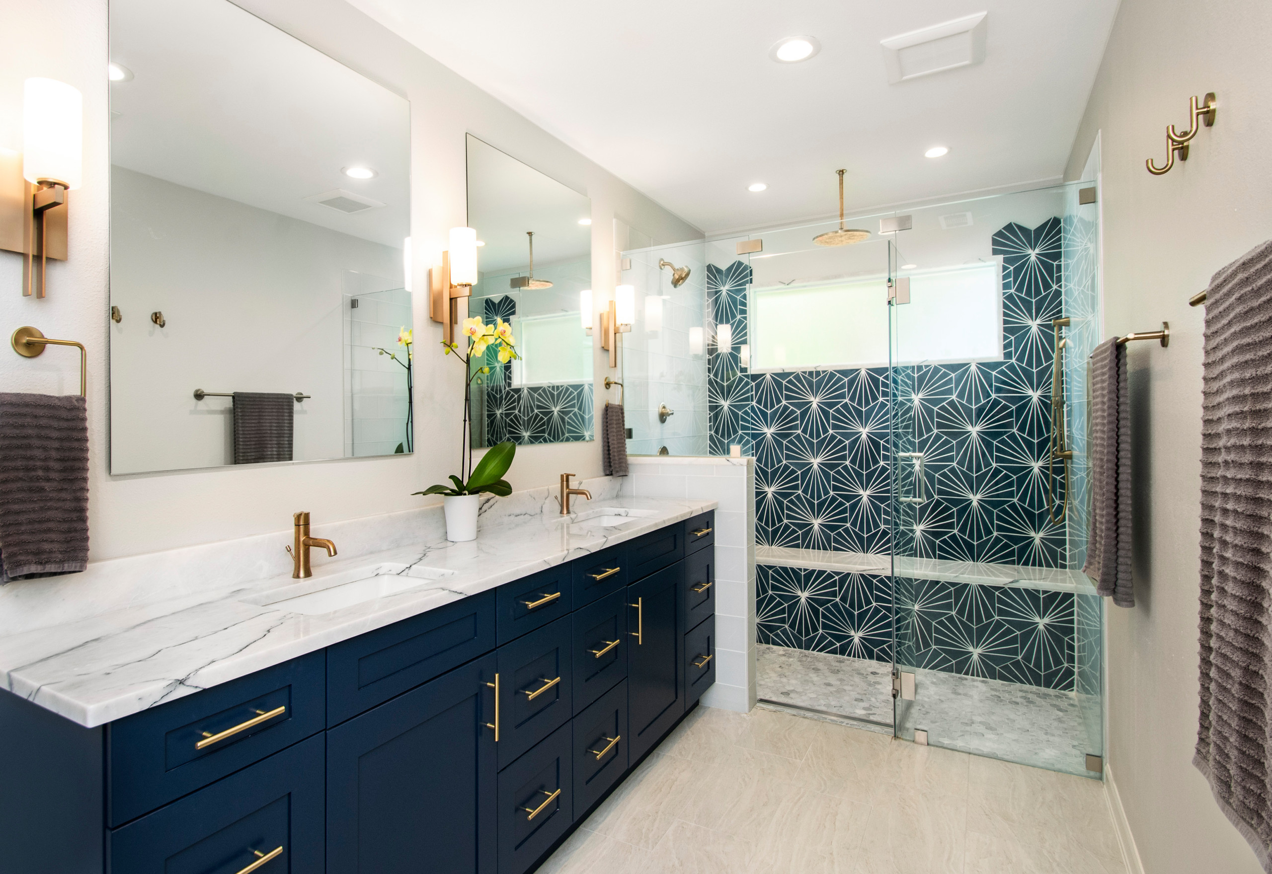 Modern bathroom with navy blue vanity and geometric shower tiles