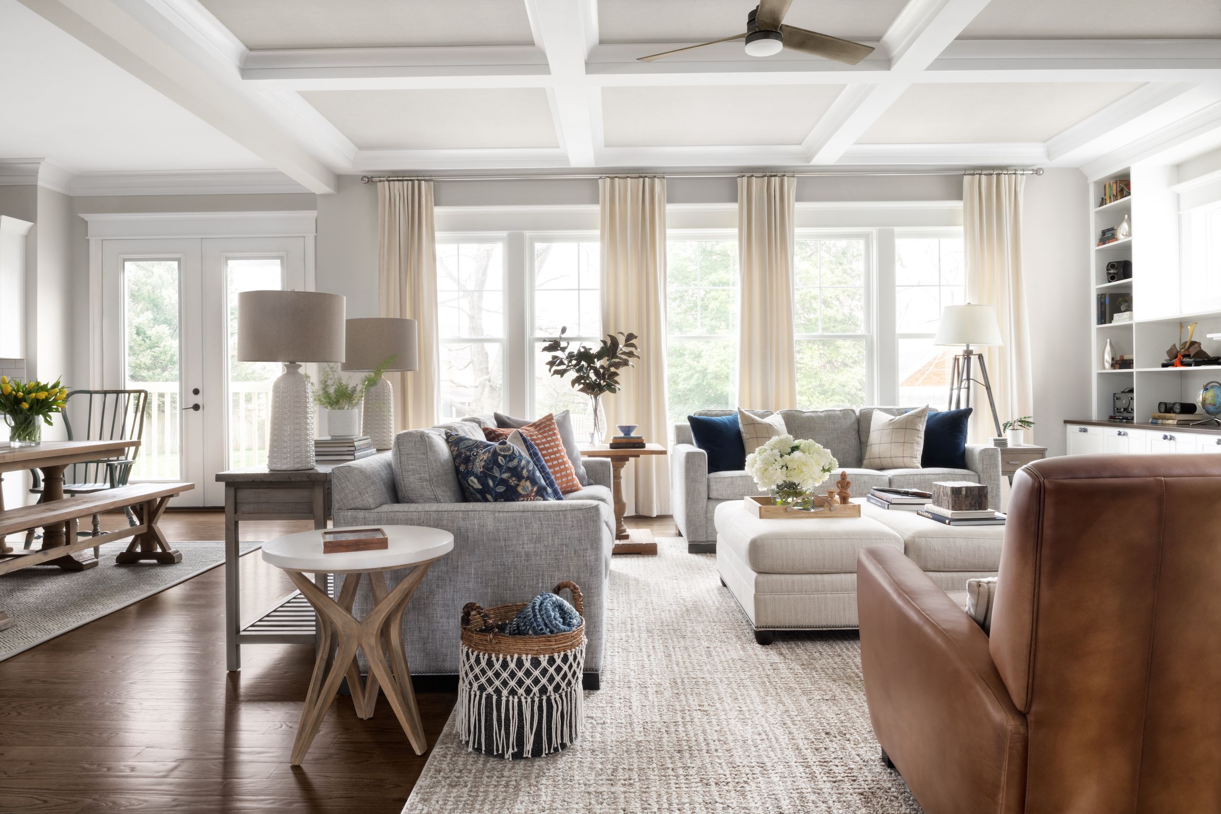 Elegant living room with neutral tones, large windows, and cozy seating.