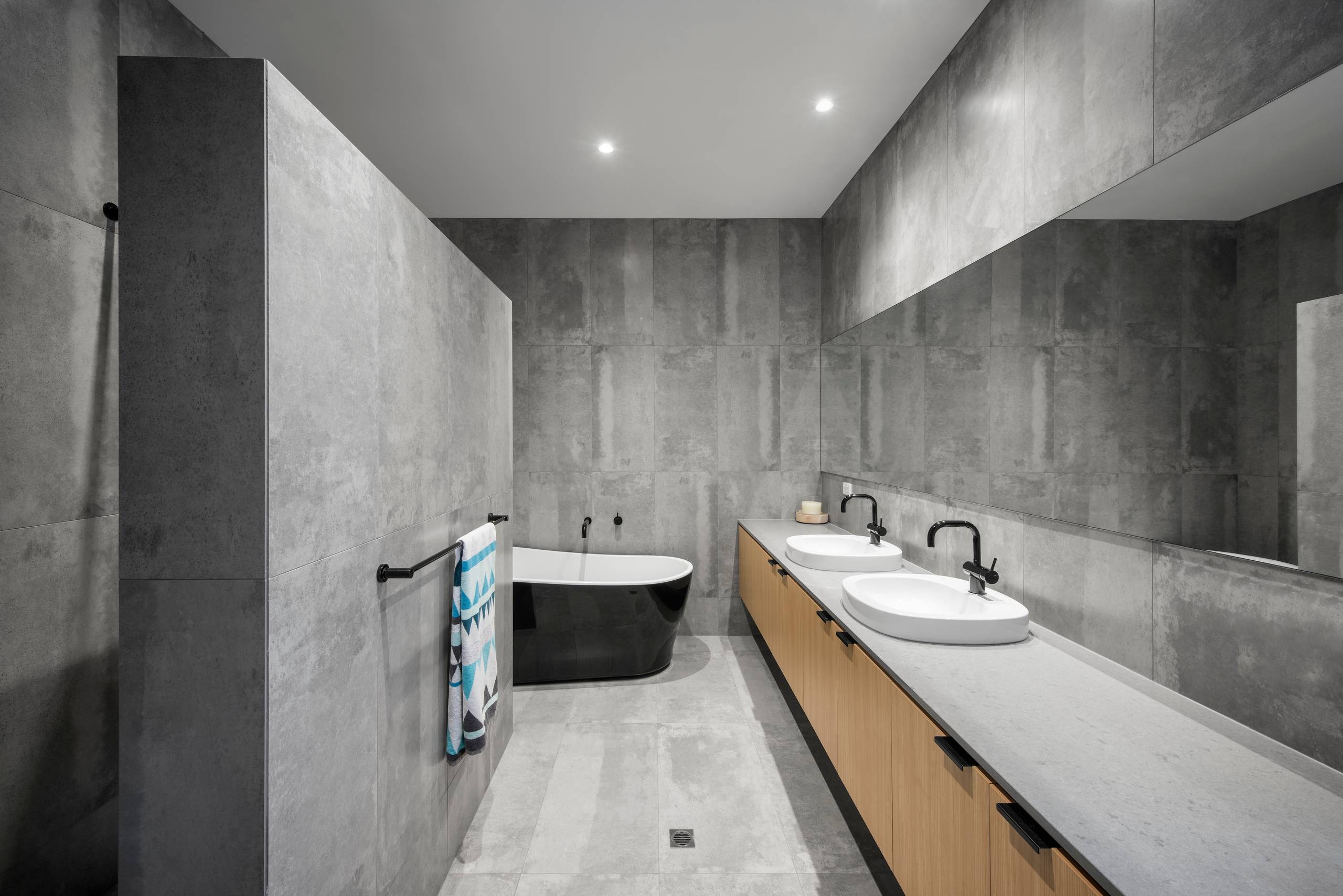 Minimalist bathroom with concrete walls and modern black fixtures