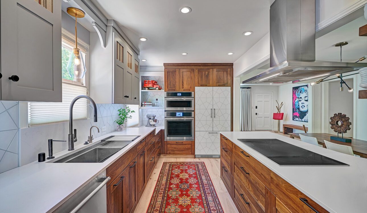 Modern galley kitchen with wood cabinets and white countertops.