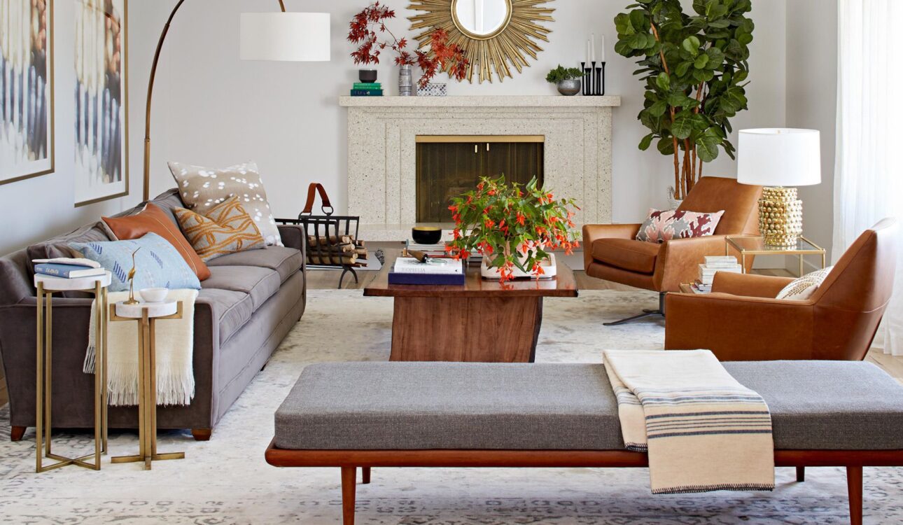 Stylish living room with a sunburst mirror, fireplace, and modern furniture.