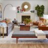 Stylish living room with a sunburst mirror, fireplace, and modern furniture.