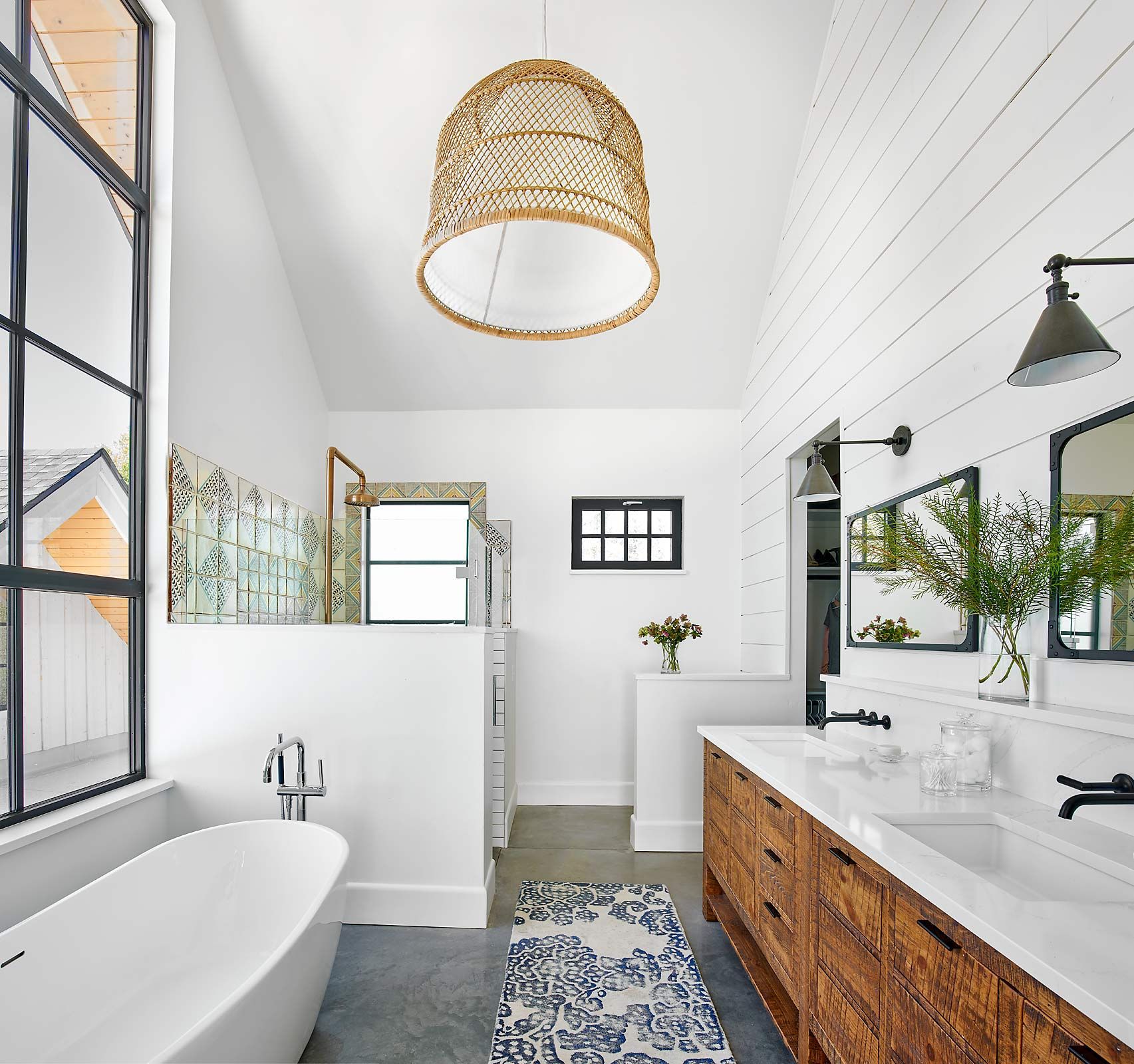 Bright farmhouse-style bathroom with freestanding tub, wood vanity, and patterned tiles.