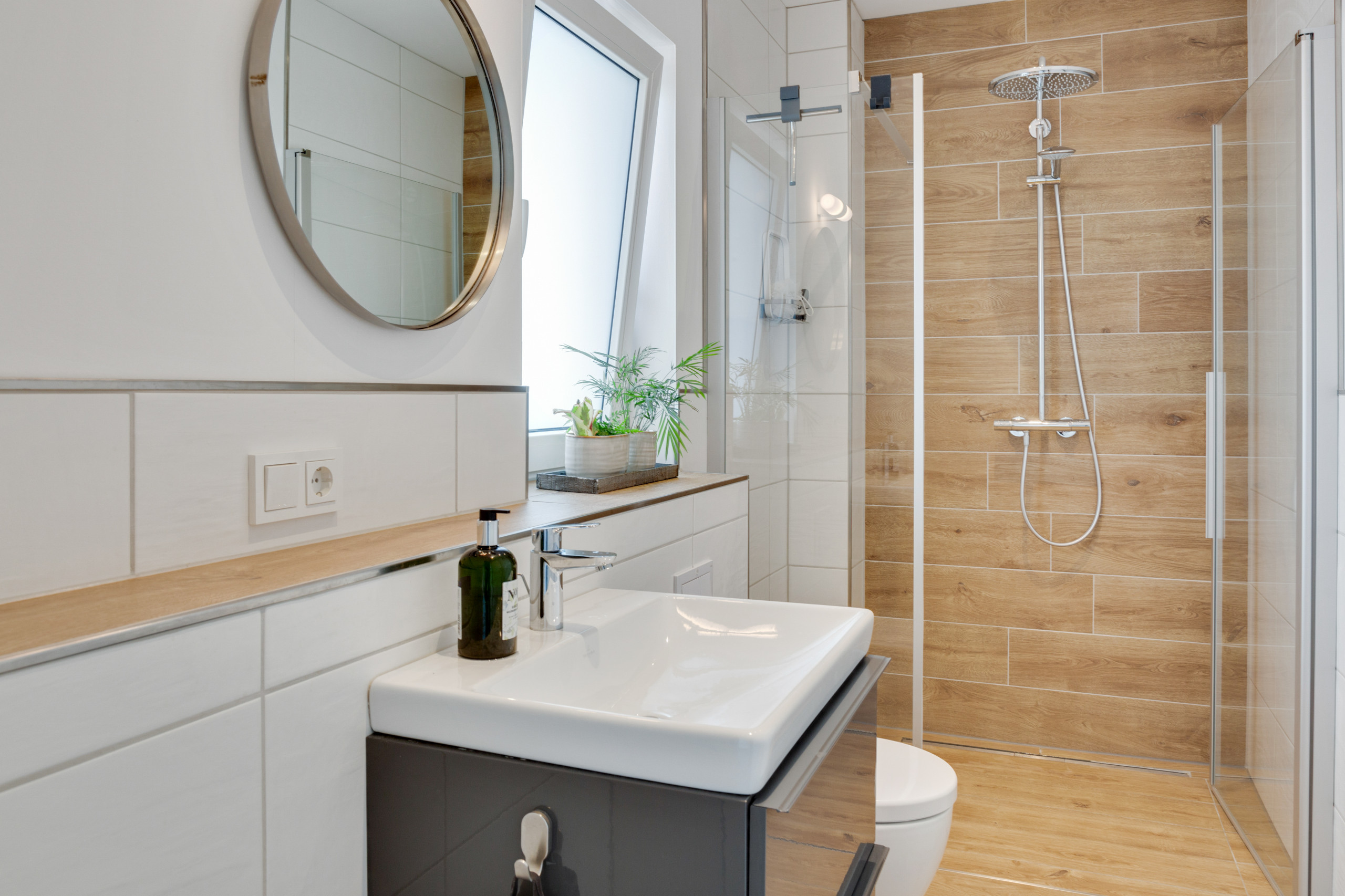Modern bathroom with wood-effect shower wall and sleek vanity.