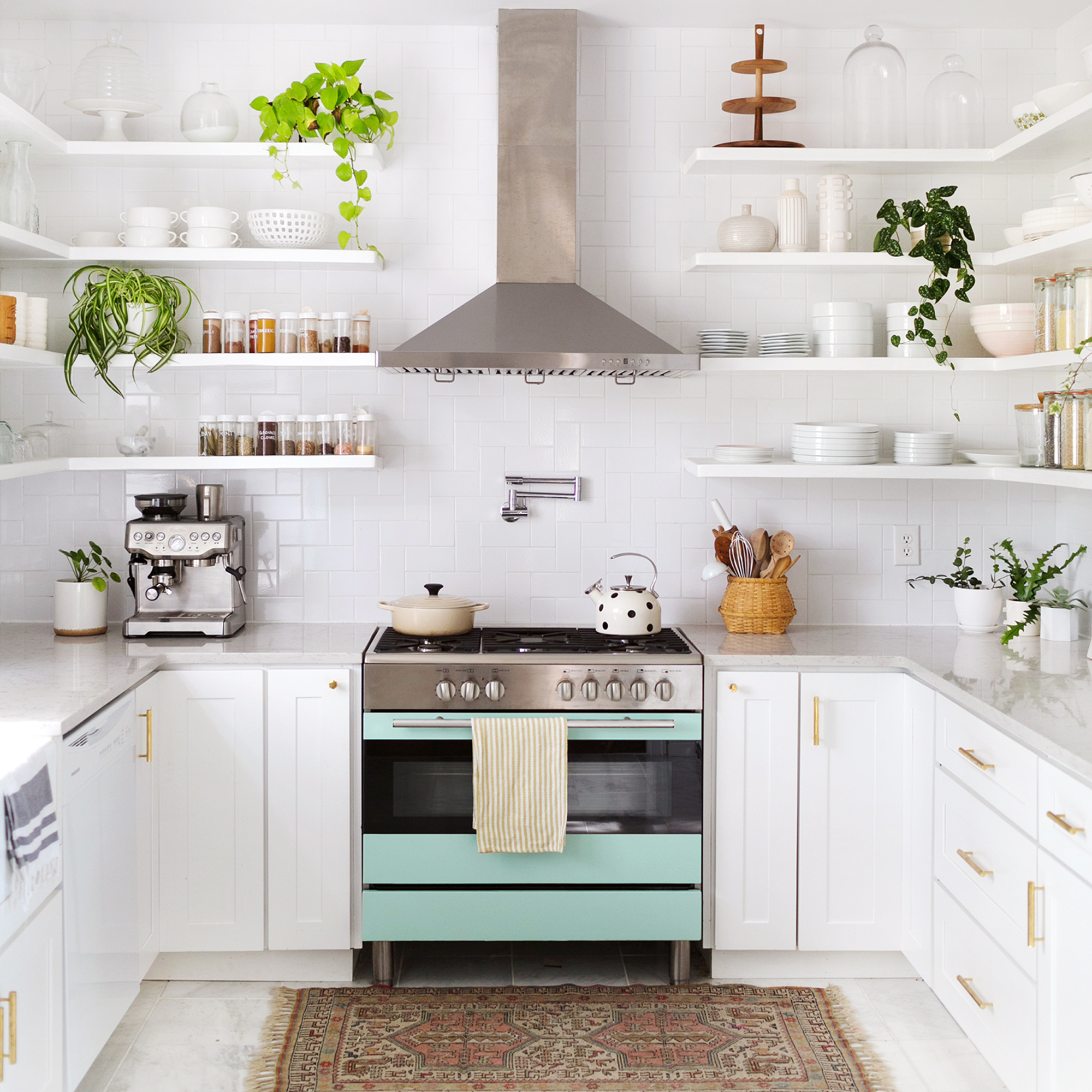 Bright white kitchen with mint green oven and open shelving