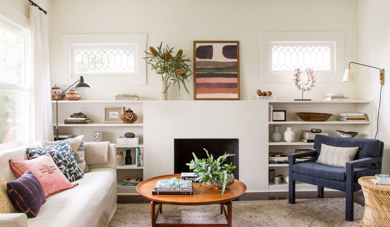 Cozy modern living room with neutral tones, mid-century furniture, and built-in shelving.